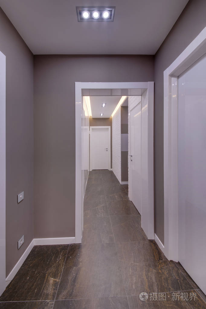 一条有门的大走廊砖砌的装饰墙和一层深色的地板