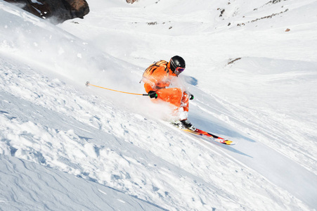 滑雪运动员在一个新鲜的雪粉冲下雪坡