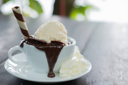 巧克力熔岩蛋糕和香草冰淇淋。甜点在白色杯子