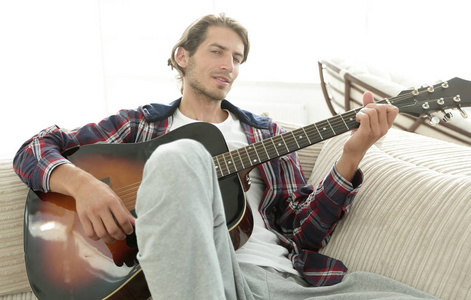 现代吉他坐在客厅沙发上的家伙