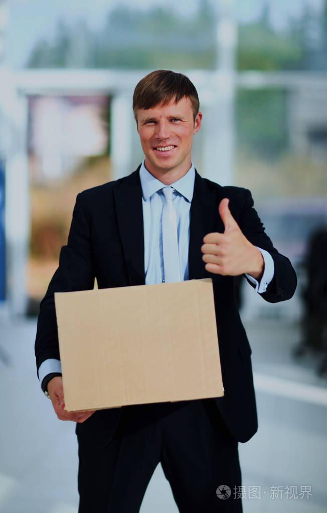 微笑的生意人拿着一个纸板盒