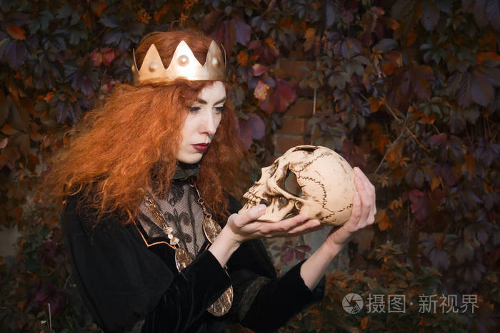 一只手拿着剑的中世纪女王和骷髅