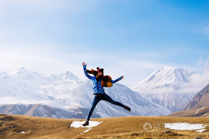 活跃的年轻女孩旅行者在高加索山脉附近跳跃