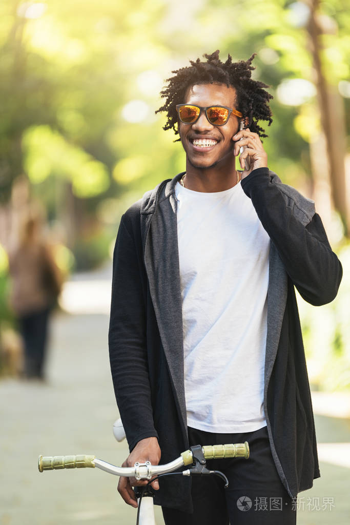 使用手机和固定齿轮自行车的非洲年轻人照片-正版商用图片025n31-摄图