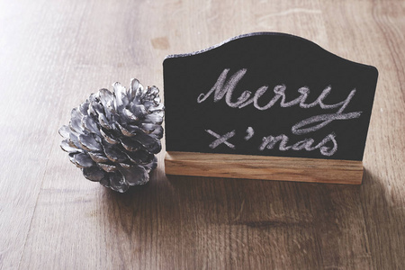 圣诞快乐文本符号与松木装饰在乡村的木质背景