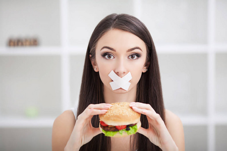 饮食.年轻的妇女与管道胶带在她的嘴, 防止她