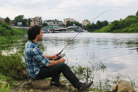 一个留着胡子的男人在河里钓鱼