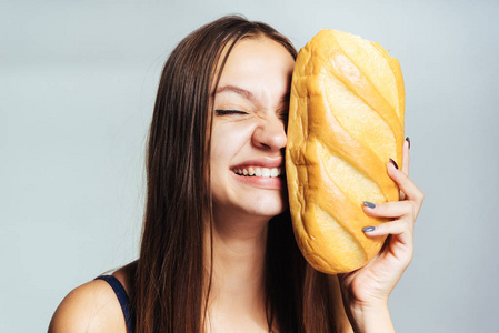 年轻运动微笑女孩看着他的身影，抱着在他手有害白面包