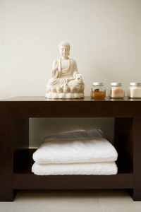 浴室里有毛巾和油的佛石雕像