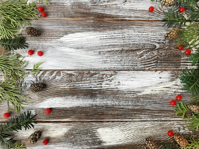 圣诞节的木制背景。布局与树枝, 红色浆果, 松树锥在旧木板。复制空间。新年边界