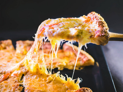 切掉一块披萨融化的奶酪从片中伸展