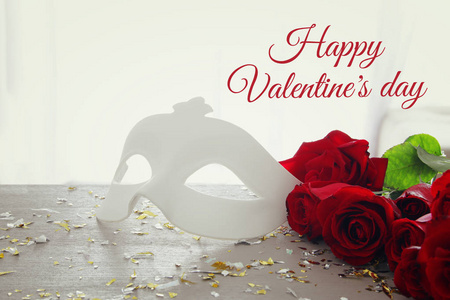 情人节浪漫的背景与美丽的玫瑰花束和化妆在木桌上的白色面具