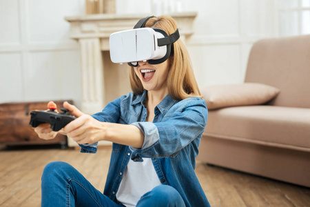 穿着虚拟现实眼镜, 使用遥控器的欣喜若狂的妇女