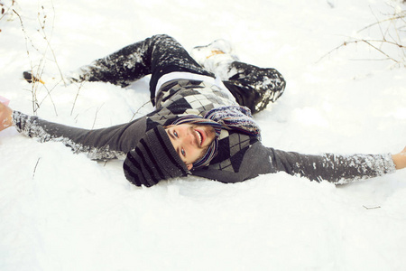 英俊的男人躺在雪上