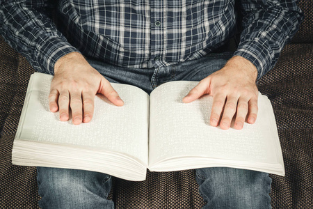 盲人正在读一本盲文书.触摸你照片