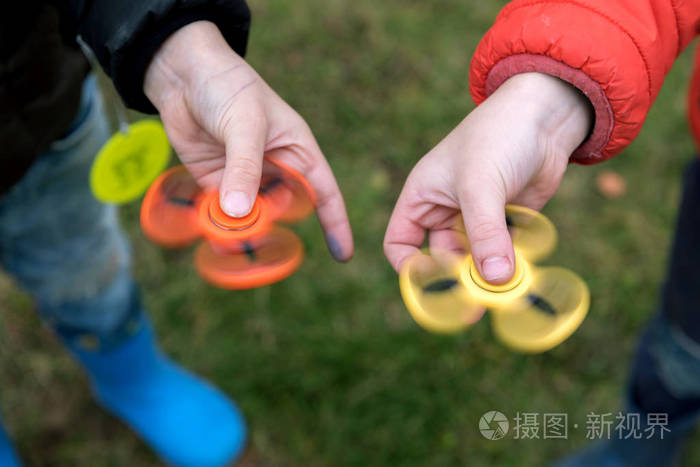 两个男孩在玩坐立不安的陀螺室外