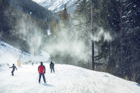 一群人在山斜坡上滑雪的后视图