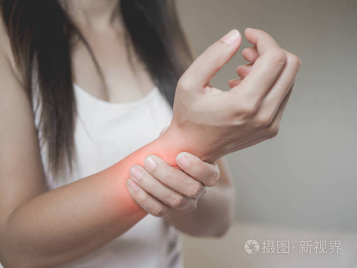 特写女人抱着她手腕的手受伤,疼痛的感觉