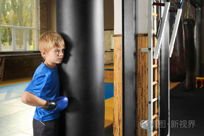 可爱的小男孩站在众矢之的附近的健身房