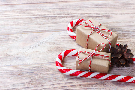 新年礼物在一个自制的盒子与红弓附近的圣诞糖果手杖
