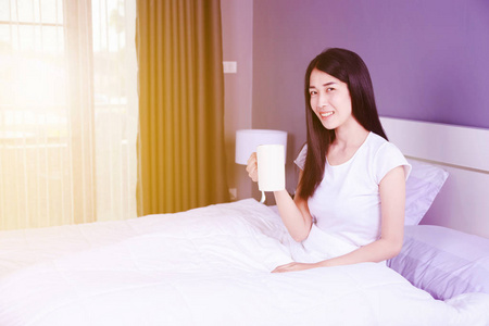在床上的妇女与一杯咖啡在卧室
