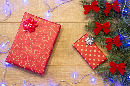 新年圣诞礼品包, 树与红色蝴蝶结和蓝色花环的木制背景模板