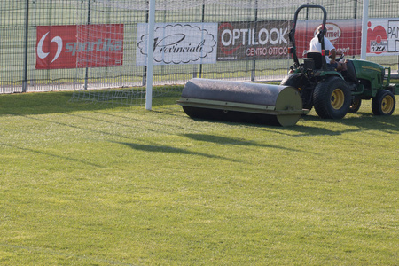 在比赛前, 工人在足球场上驾驶草坪设备