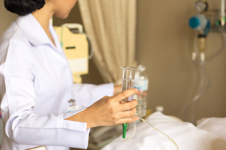 护士给病人用水用玻璃注射器冲洗 nasog