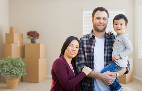 混血华人和白种父母和孩子在空房间里搬箱子