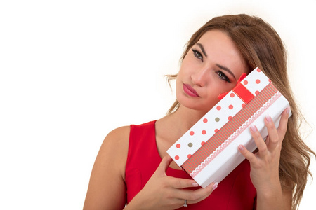 休闲年轻快乐微笑女人肖像举行红色礼品盒。孤立的工作室背景女性模型