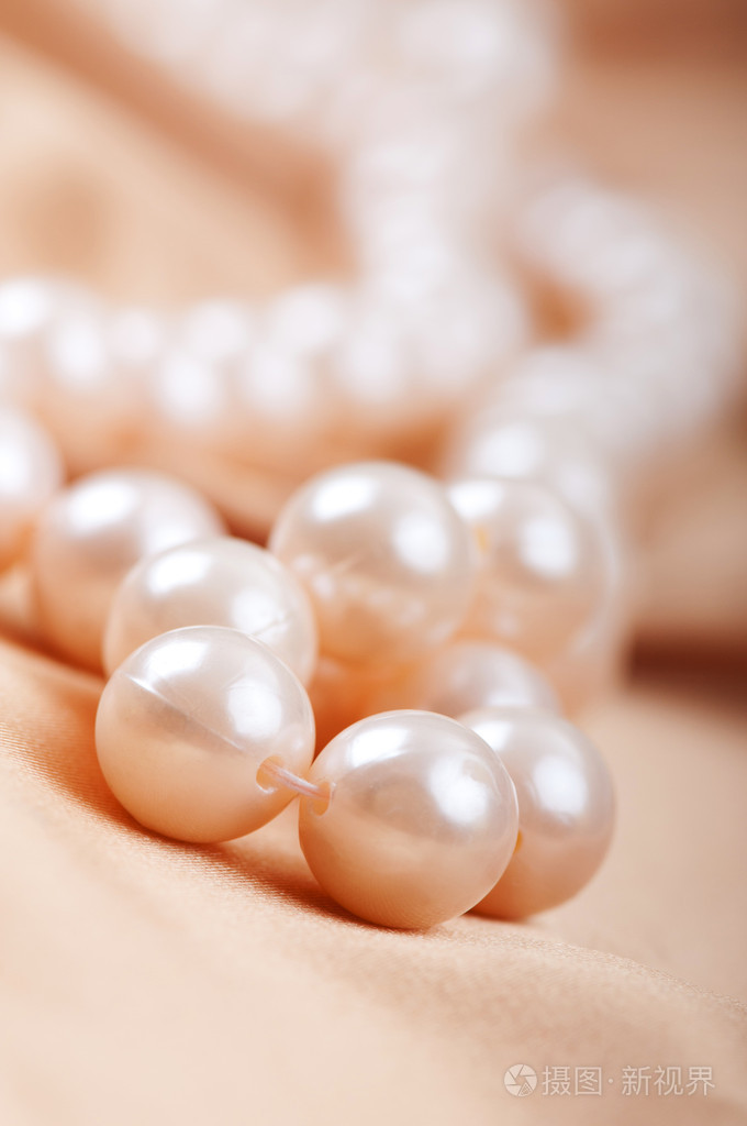 珍珠项链在明亮的缎子背景上