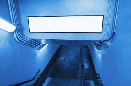空白广告牌或灯箱在地铁站入口处上方的隧道, 文本信息或媒体内容的复制空间, 广告, 商业, 营销概念, 蓝色色调