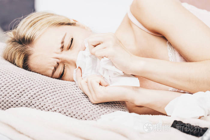 生病的妇女躺在床上高热。感冒, 流感, 发烧和偏头痛的温度计和触摸她的额头。在压力