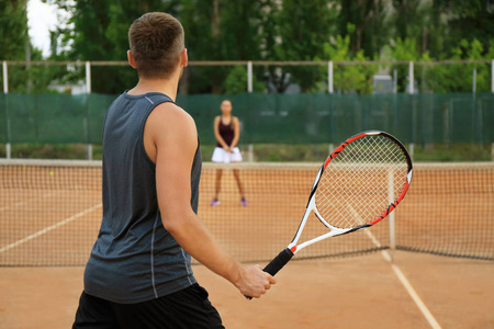 在球场上打网球的男女青年