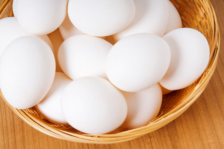 木桌上有许多白鸡蛋桌子上有鸡蛋和破壳黑色背景上有鹌鹑复活节彩蛋和