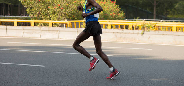 长跑运动员马拉松长跑运动员的腿在城市路照片