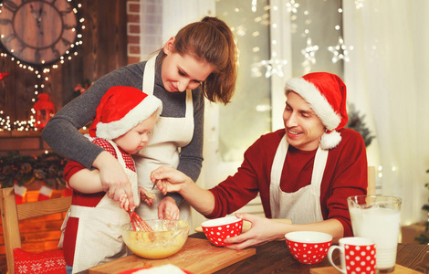 家庭母亲爸爸和婴孩烘烤圣诞节曲奇饼