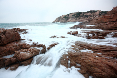 美丽的海景。 日落时的大海和岩石。 自然构成