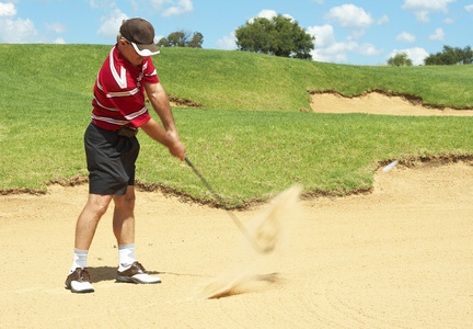 高级高尔夫球手从沙坑打高尔夫