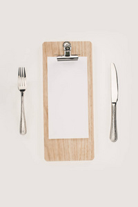 剪贴板和餐具上的空白纸张