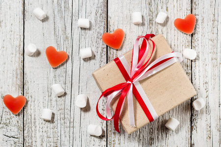 情人节糖果心软糖和工艺纸的礼物盒白色木背景