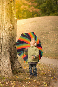 小男孩躲在后面多彩伞户外图片