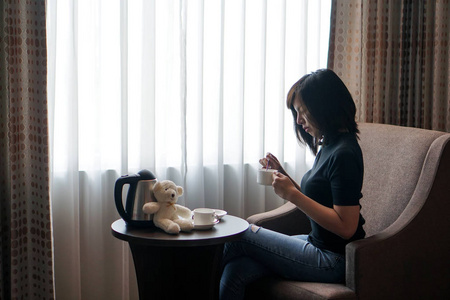 妇女在旅馆房间里喝咖啡的窗口