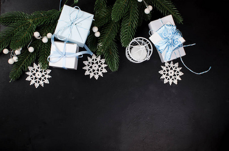 黑色背景的圣诞冷杉树枝和礼品盒