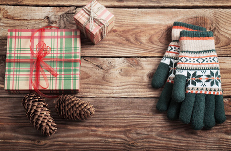 木制背景的圣诞礼物和手套