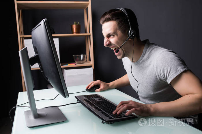 愤怒的尖叫声耳机与 pc 电脑在家里玩游戏的年轻人和流 playthrough