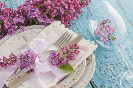 餐具和银器与一束紫罗兰色丁香木背景