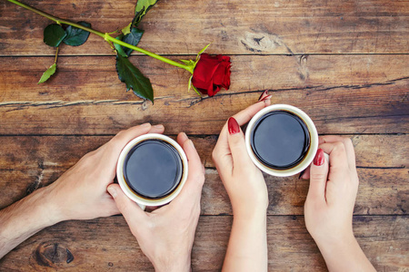 杯中的咖啡在男人和女人的手中。选择性焦点