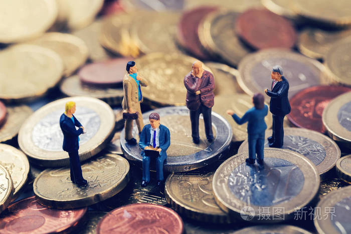 一群业务人站在欧元钱堆栈和谈