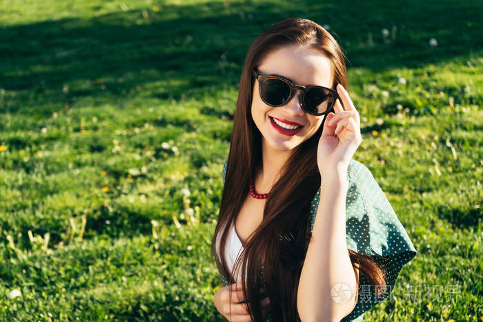 美丽的女人在草地上的背景, 太阳镜, 微笑